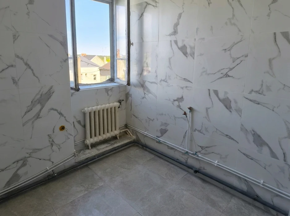 Salle de bain en rénovation, murs carrelés en grand format imitation marbre Calacatta blanc veiné gris