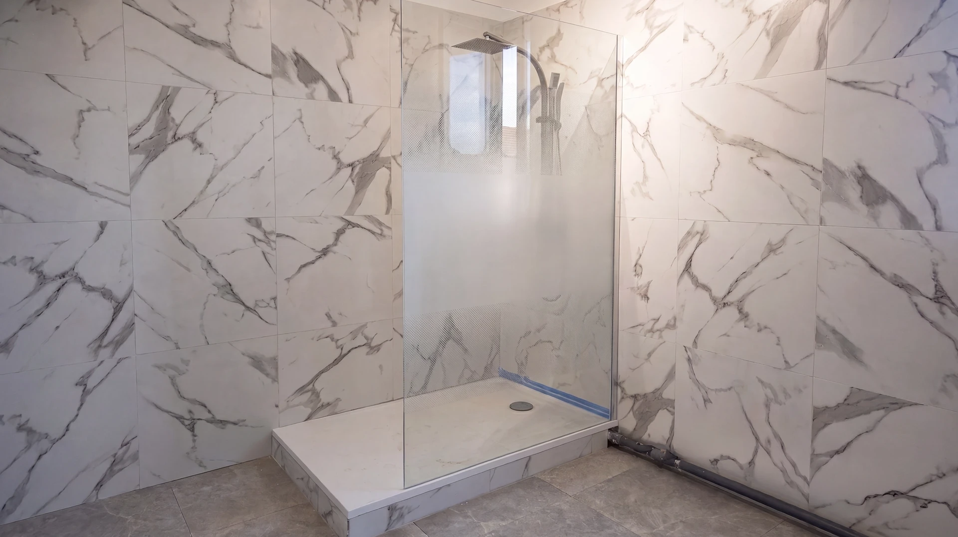Salle de bains moderne avec baignoire îlot blanche, meuble vasque suspendu gris anthracite, WC suspendu et carrelage mural blanc